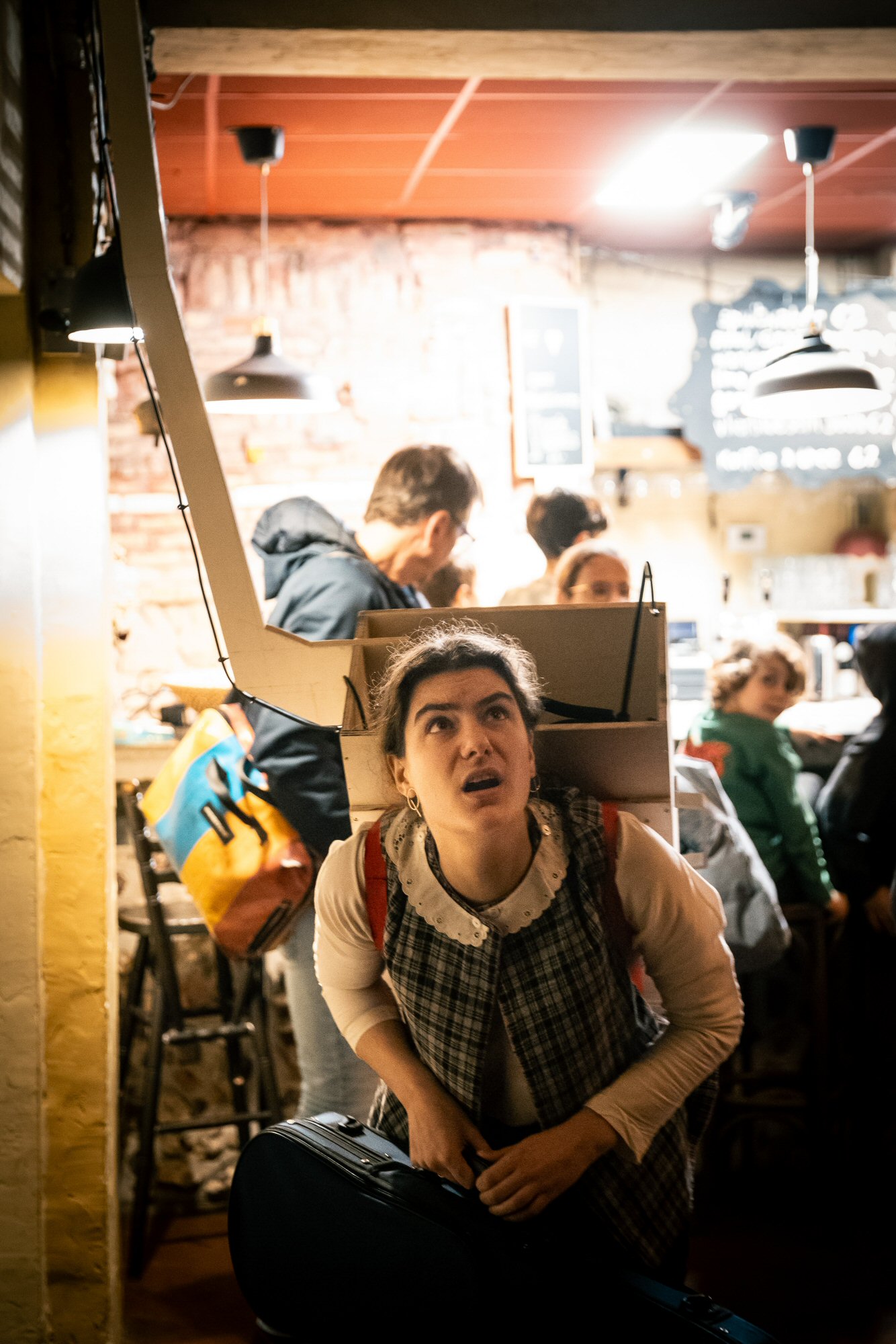 Eva Mareen, die probeert te navigeren met een houten boekentas waar iets lang uitsteekt